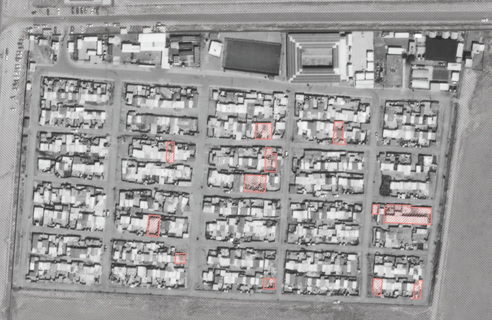 Satellite image of the camp’s grid of plots, with the surveyed homes outlined in red.
