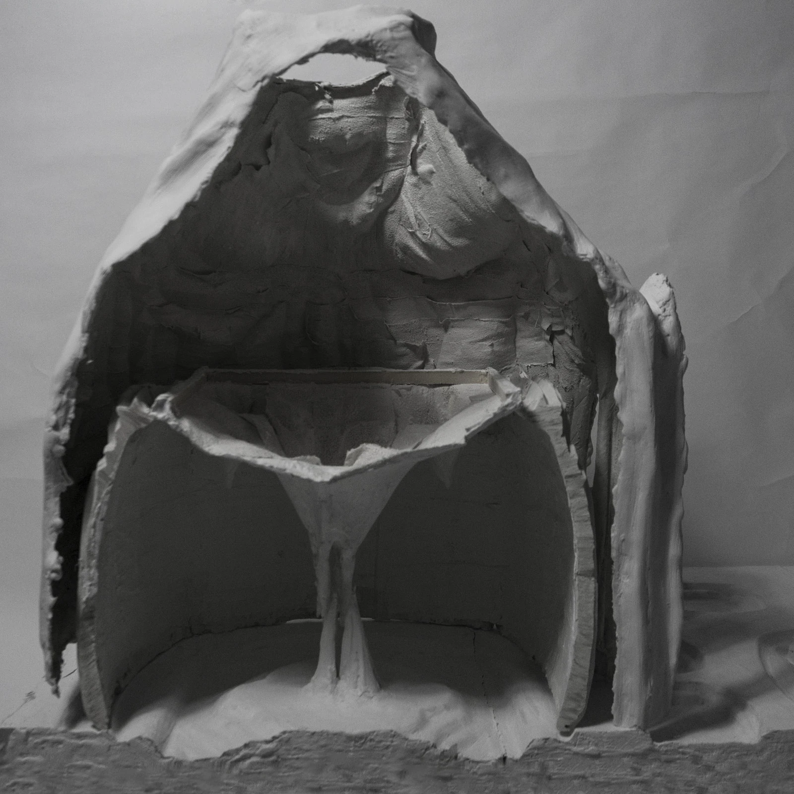 Black-and-white photo of a plaster shell cast cut in section, showing its thin wall.
