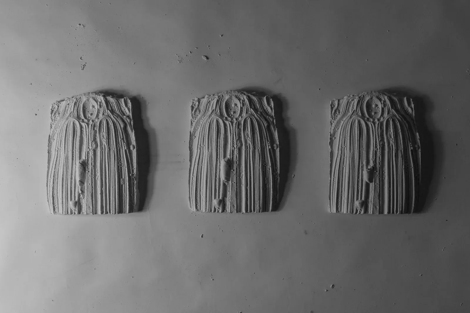 Three small plaster tiles cast with ribbed patterns.