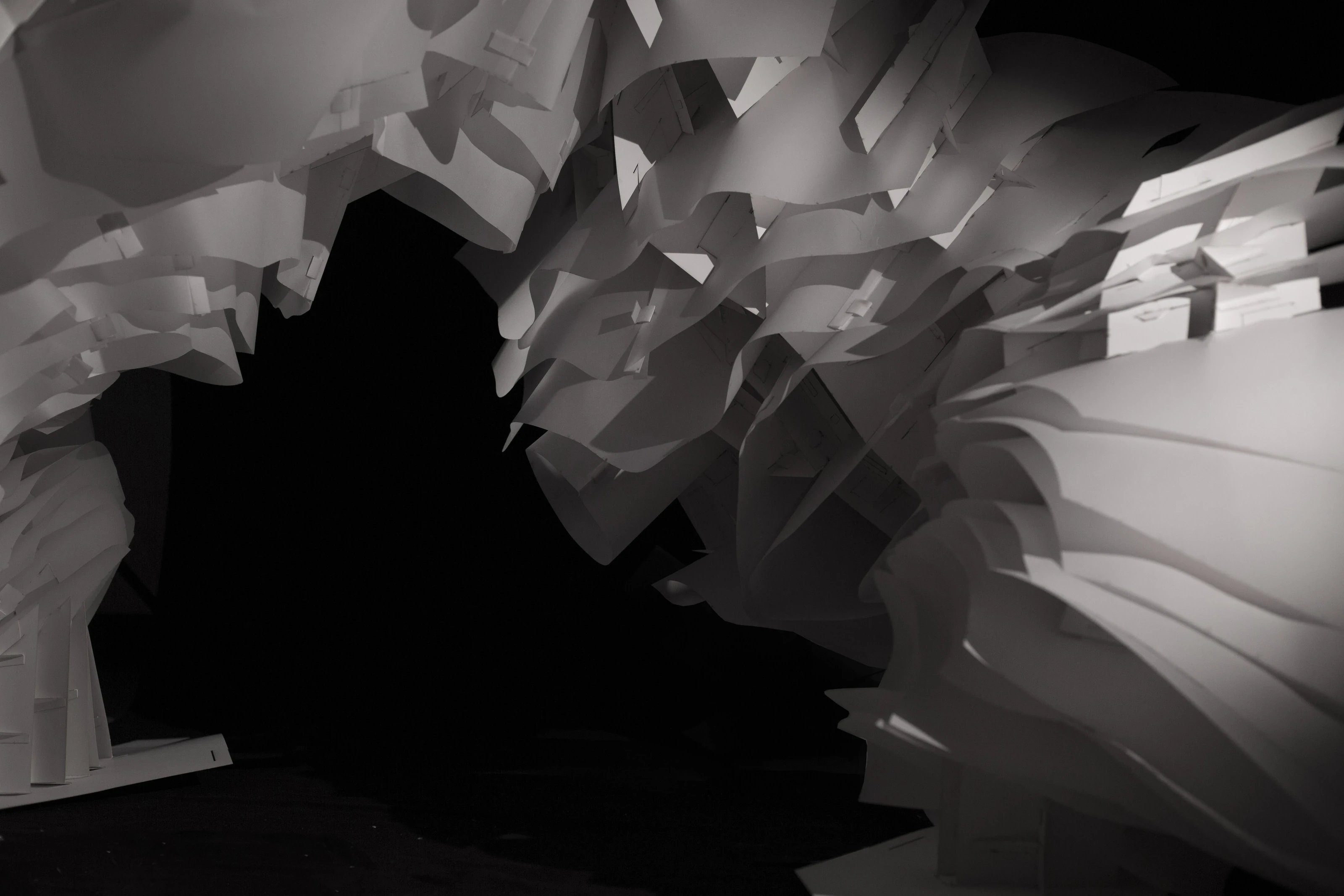 The cave’s mouth: a dark void framed by layers of white paper.