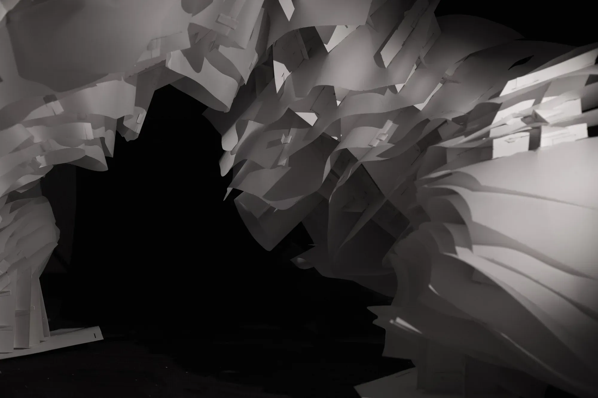 The cave’s mouth: a dark void framed by layers of white paper.